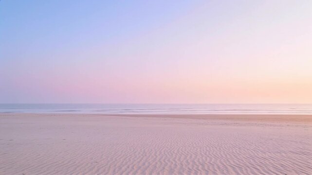 Showing empty sandy beach and horizon slowly warming at sunrise, with rippled wet sand, calm sea