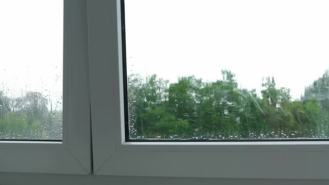 Rainfall on window during a cloudy day in a home setting