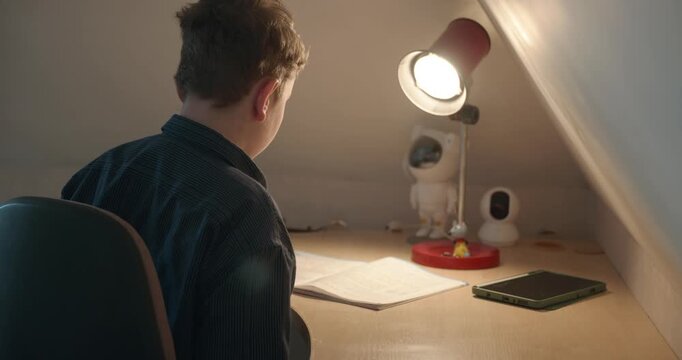 Kid Boy Doing Homework in Workbook Writing with Pen on Table Desk. 4K 10-bit