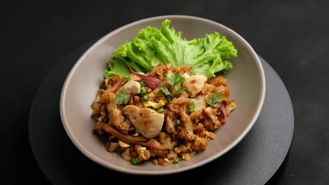 Stir fried Rice Noodles with Chicken.stir fry flat noodles with chicken ,Pickled squid and egg in a plate. (Kuay Teow Kua Gai)