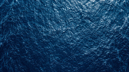 Moody dark blue ocean surface water background texture with gentle wave patterns © Luiz