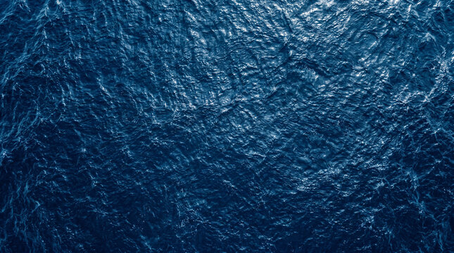 Moody dark blue ocean surface water background texture with gentle wave patterns
