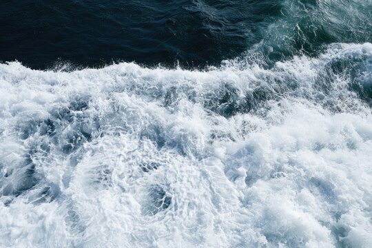 Turbulent ocean waves churn white foam against deep blue water