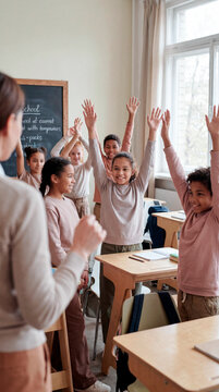 Enthusiastic elementary students raising hands eagerly in bright modern classroom