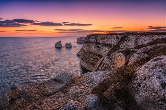 Limestone cliffs overlooking sea stacks during sunset coastline