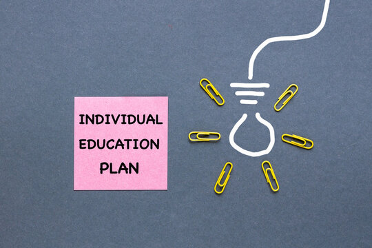 An individual education plan written on a pink sticky note and a hand-drawn light bulb. Business concept, IEP 504 Program, space for text. Gray background