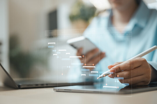 Business professional managing a digital Gantt chart for project scheduling, workflow and task planning on tablet.