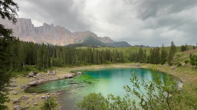 Wide view of Lake Carezza with Latemar mountain range in Dolomites, South Tyrol, Italy. Ideal for travel, nature, and outdoor adventure concepts