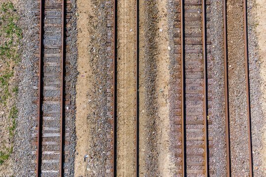Aerial view of multiple parallel railroad tracks, gravel, and dirt