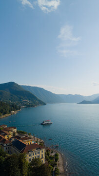 Lake como's scenic beauty captivates with a ferry traversing its deep blue waters, framed by majestic mountains and charming lakeside villas