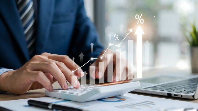 Close up of businessman in blue suit working on calculator with financial growth chart and interest rate increase