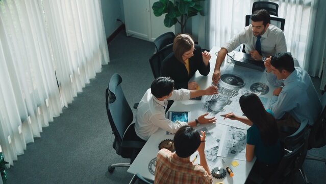 Group of diverse team planning strategy while sitting at table with project plan. Top aerial view of smart business people working together to brainstorm and design house construction. Alimentation.