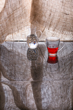 Still life with a red bottle, decanter and glass