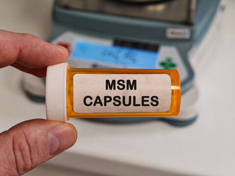 MSM CAPSULES joint and connective tissue supplement for joint cartilage and connective tissue support held by pharmacist in pharmacy laboratory