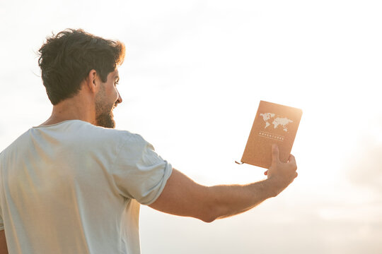 Man holding adventure notebook dreaming of travel and freedom