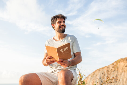 Man enjoying digital detox by reading adventure book outdoors