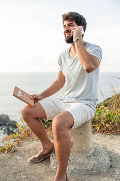 vertical Young remote worker talking on phone enjoying nature view