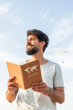 vertical Man dreaming of adventures and digital detox with world map notebook