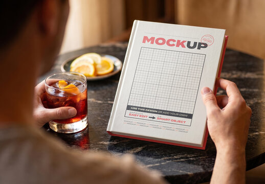 Book Hard Cover on Bar Table with Drink Mockup