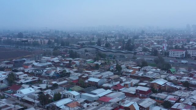Aerial view of crowded houses in a suburban residential neighborhood in Santiago de Chile on a foggy day