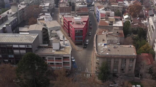 Aerial view of a unique triangular red residential building at a street intersection in Santiago de Chile