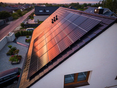 Photovoltaic panels under sunset sky on new build house