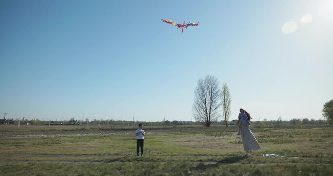 Children with mother flying a kite. Family spend time together on nature. 4K 10-bit