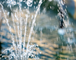 a close-up of water spraying upward from a fountain. abstract freshness, flowing energy, or water impact background © mailcaroline