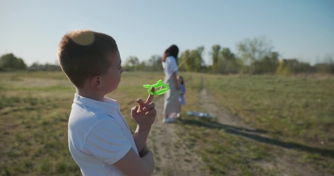 Children with mother flying a kite. Family spend time together on nature. 4K 10-bit