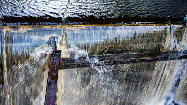 Floodgate metaphor background. Water cascading down a low head dam or water management system, creating a curtain effect.