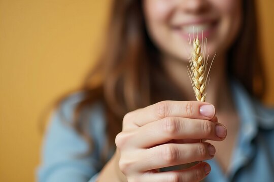 Symbolic Photo of a Woman Holding a Spikelet of Wheat: Representing the Difficulties of Celiac Disease and Gluten Intolerance.