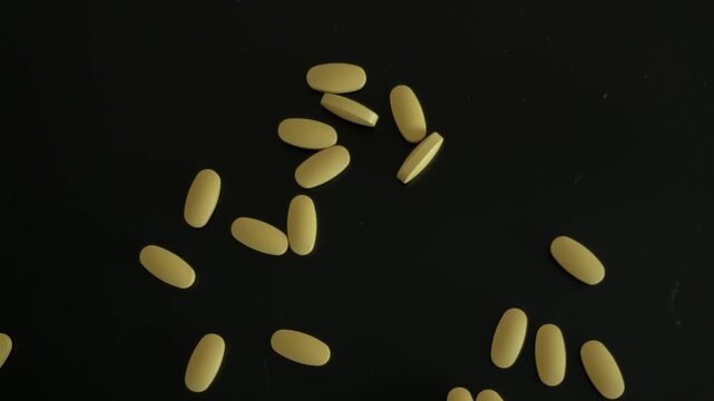 Hand Counting Yellow Pills Top View