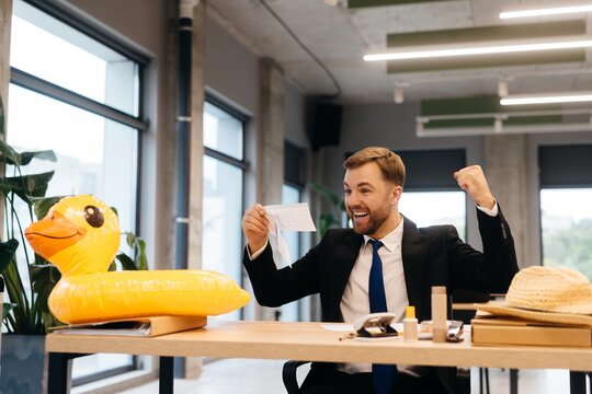 Businessman celebrating vacation booking in office