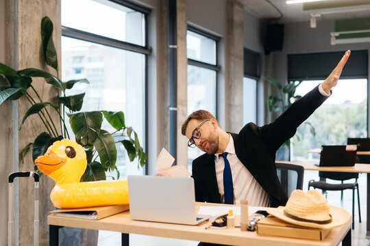 Businessman daydreaming about tropical vacation at office desk