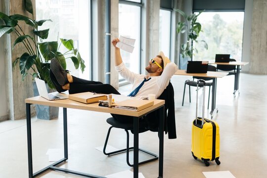 Businessman dreaming of a tropical vacation at office desk
