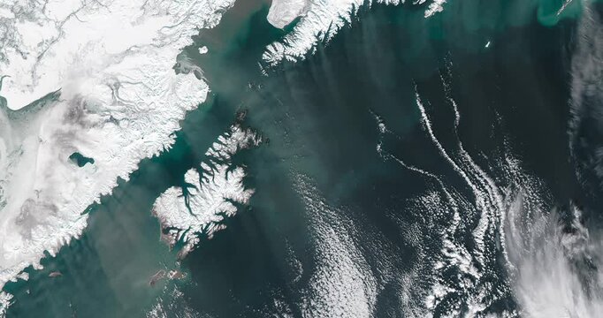 Panoramic top view of mountainous snowy coast and cloud formation. Camera is zooming out. Animation based on image by NASA