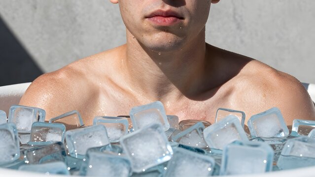 151. [STYLE] of an ice bath moment of resolve showing shoulders and clenched jaw above floating ice cubes with goosebump skin and frosted-tub textures, stark high-contrast daylight, glacial blue and f