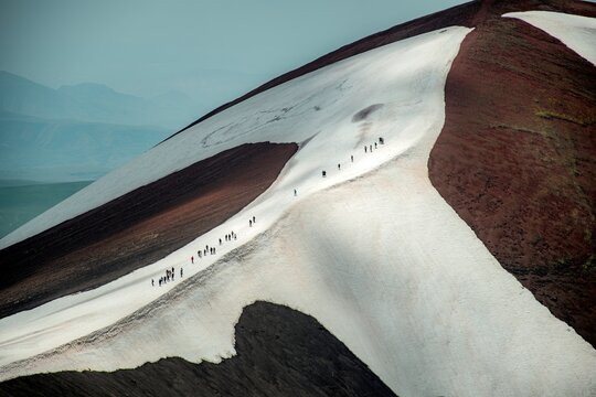 Volcanic Cinder Cone Mountain in High Altitude Alpine Meadow with Patches of Melting Snow