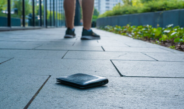 The lost wallet on the street, forgotten black leather object