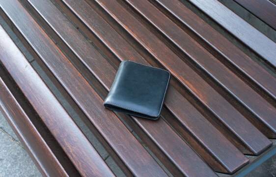 The lost wallet on the street, forgotten black leather object