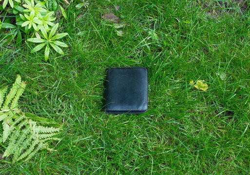 The lost wallet on the street, forgotten black leather object