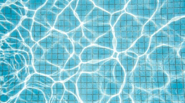 Blue tiled pool water with sunlight reflections creating bright patterns.