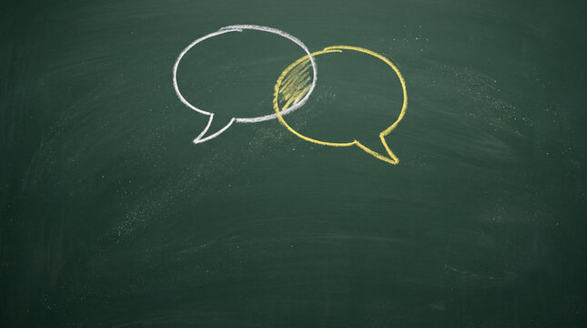 Communication concept with intersecting speech bubbles drawn in chalk on a blackboard