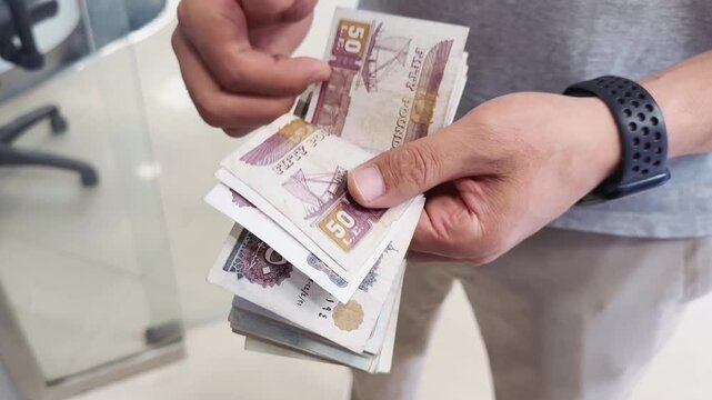 Hands counting egyptian pound cash, close-up of egyptian banknotes