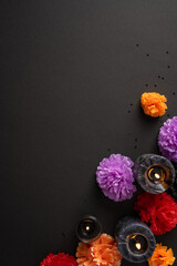Naklejka premium Decorative marigolds and candles for Dia de los Muertos altar on black vertical background