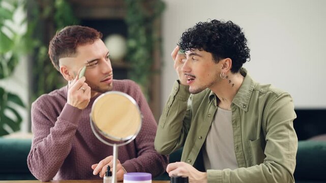 Two young men sitting together at home using jade gua sha tools for a relaxing facial massage, bonding over their shared beauty routine