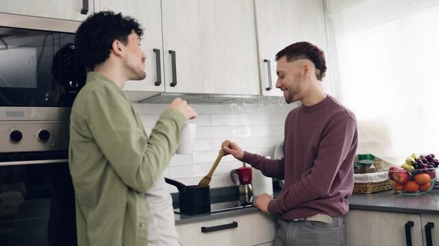 Affectionate male couple enjoying a morning routine, preparing breakfast and talking together. A beautiful moment of their domestic life