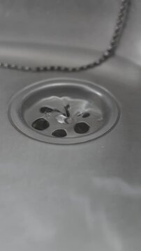 plano cercano de agua dren&aacute;ndose en una cocina