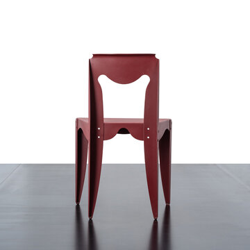 Back view of a red designer chair, made of shaped and curved aluminum.