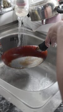 plano de una mujer lavando utensilios de cocina 